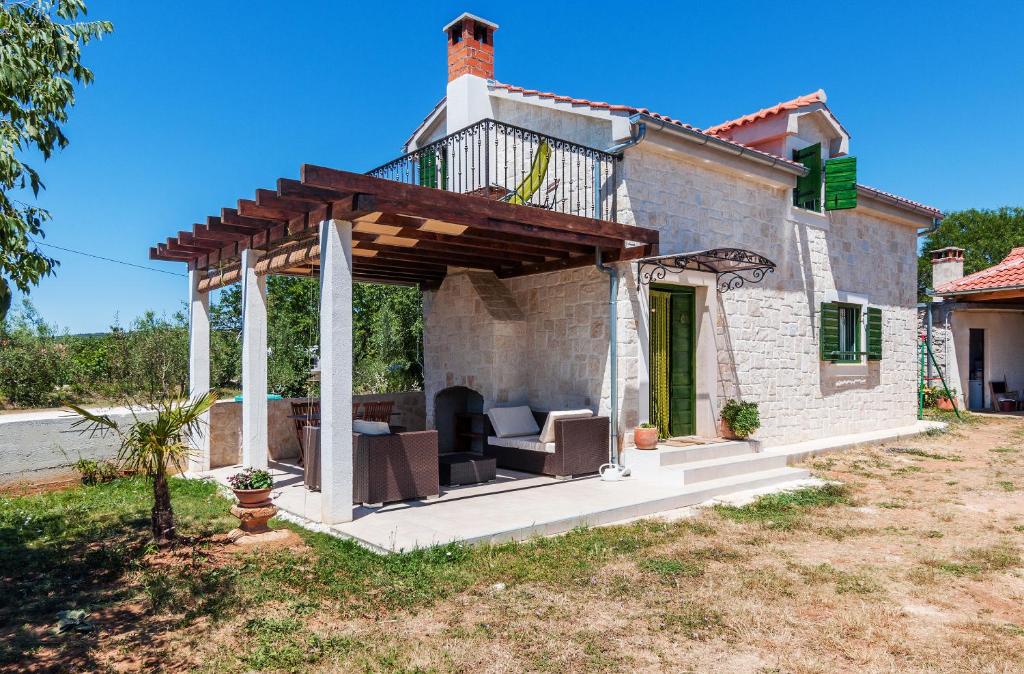 uma casa com uma pérgola na frente em Traditional Holiday Home Rita em Sukošan