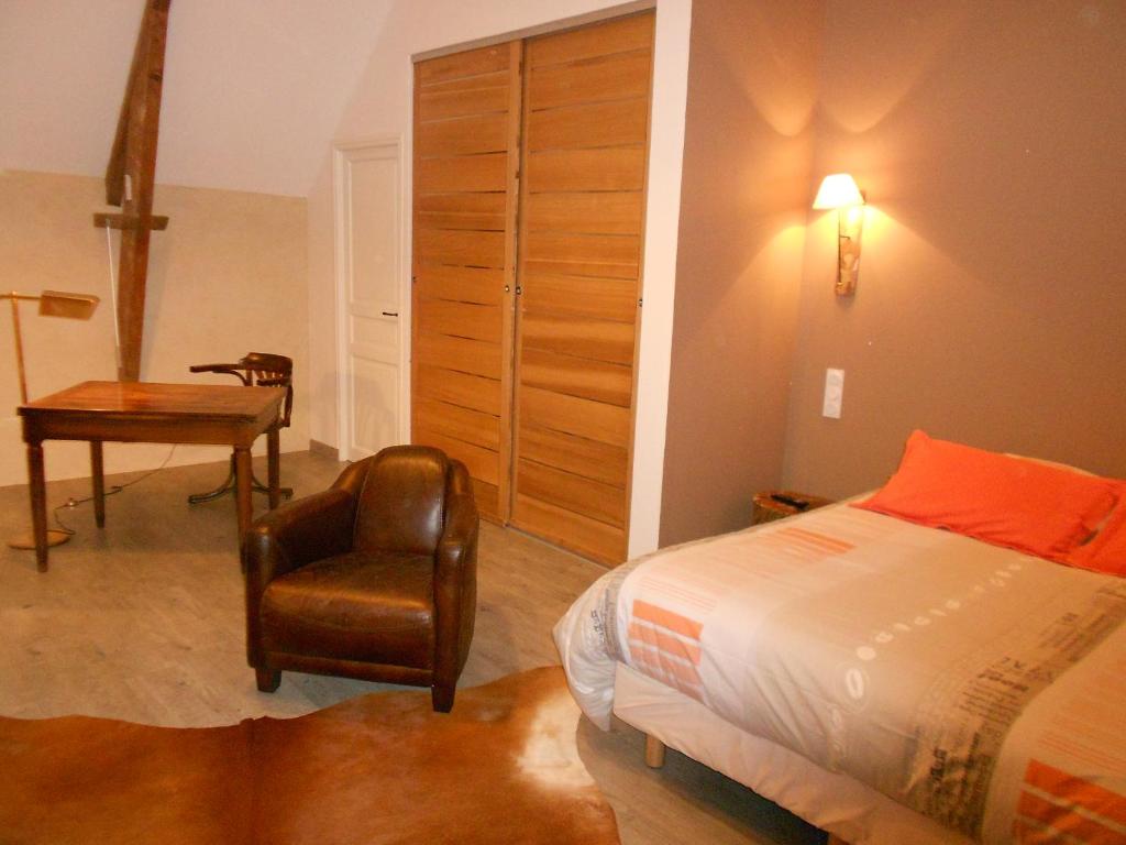 La CambeにあるFerme de Savignyのベッドルーム1室(ベッド1台、椅子、デスク付)
