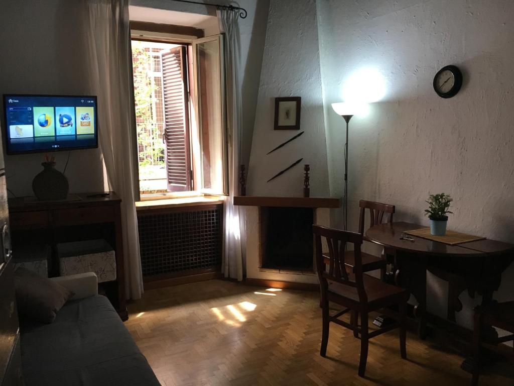 a living room with a couch and a table and a television at Vaticano Ohana Suite Trastevere in Rome