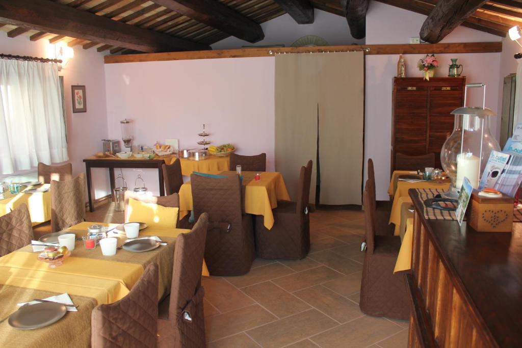jadalnia ze stołami i krzesłami z żółtą tkaniną w obiekcie Dimora di Collio w mieście San Severino Marche