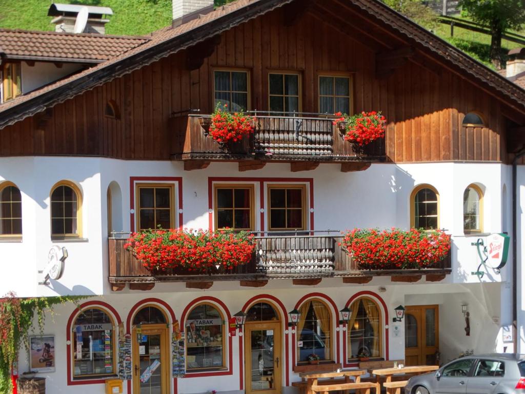 een gebouw met bloembakken op de balkons bij Ferienwohnung Bergmann in Außervillgraten