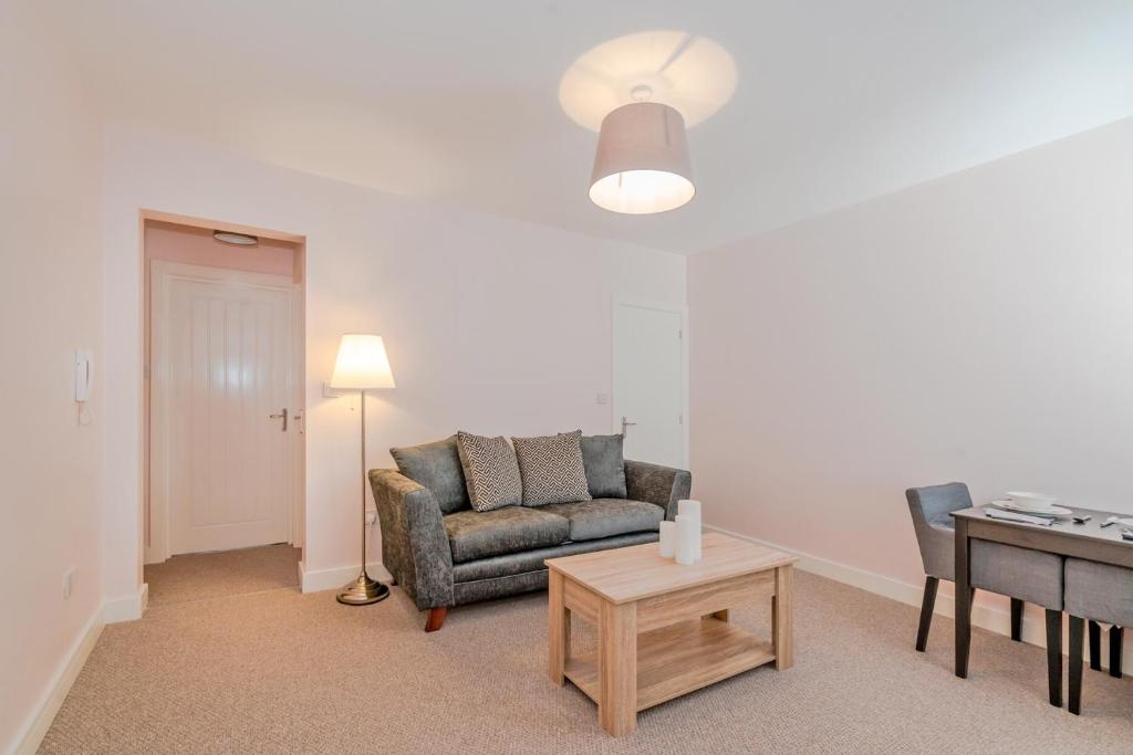 ein Wohnzimmer mit einem Sofa und einem Tisch in der Unterkunft Cannock Hotel Apartments in Cannock