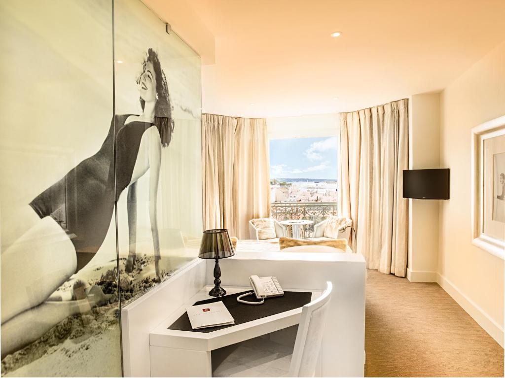 a hotel room with a picture of a woman on the wall at Hotel Renoir in Cannes