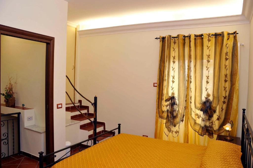 Pokój z łóżkiem i żółtą zasłoną w obiekcie Rupe Antica w mieście Artena
