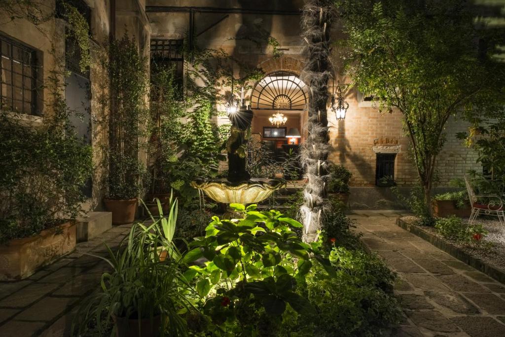 a garden at night with a fountain and plants at La Residenza 818 in Venice