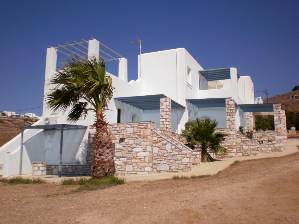 une maison blanche avec un palmier en face dans l'établissement Panorama, à Piso Livadi