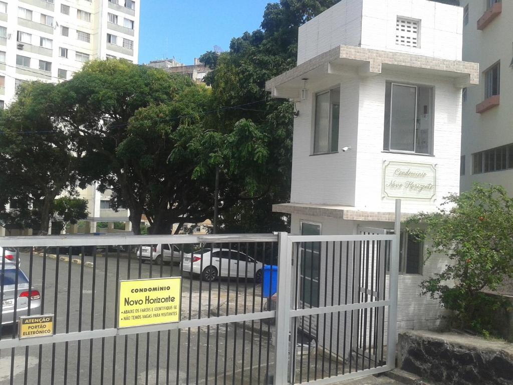 una cerca blanca frente a un edificio con señales en él en Apartamento en Salvador bahía com ar condicionado, en Salvador