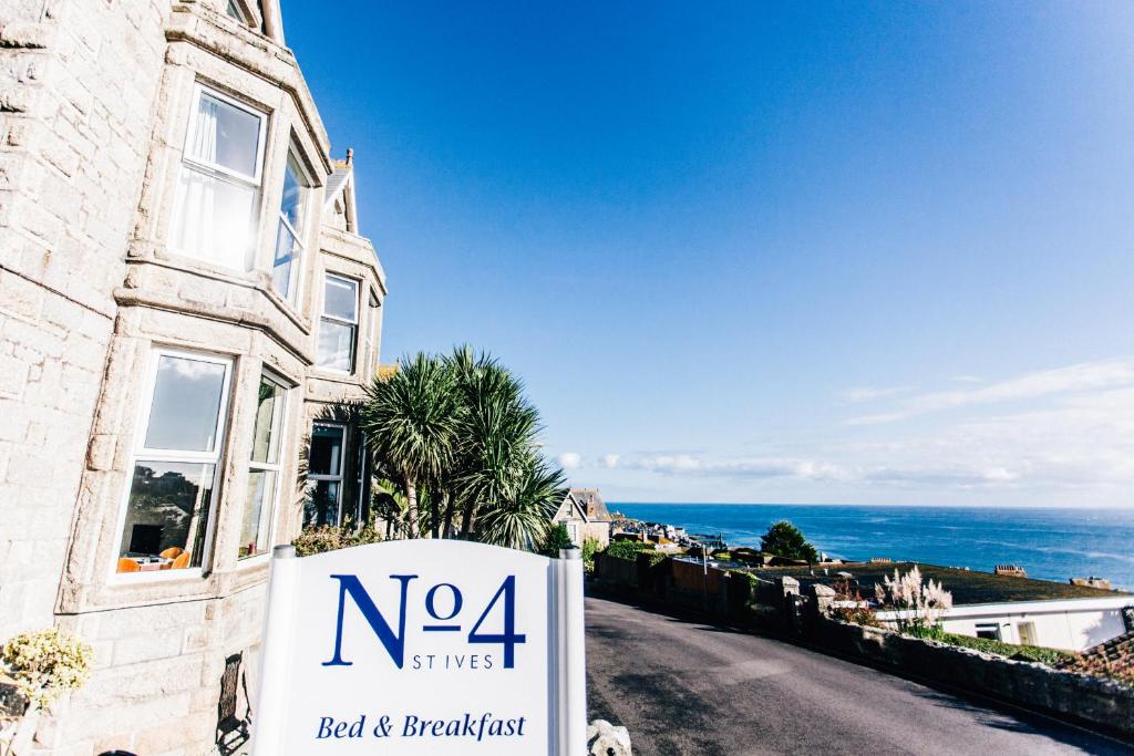 a sign in front of a building with the ocean at No4 St Ives in St Ives