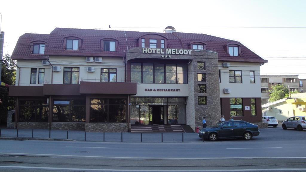 um edifício com um hotel mexicano numa rua em Hotel Melody em Oradea