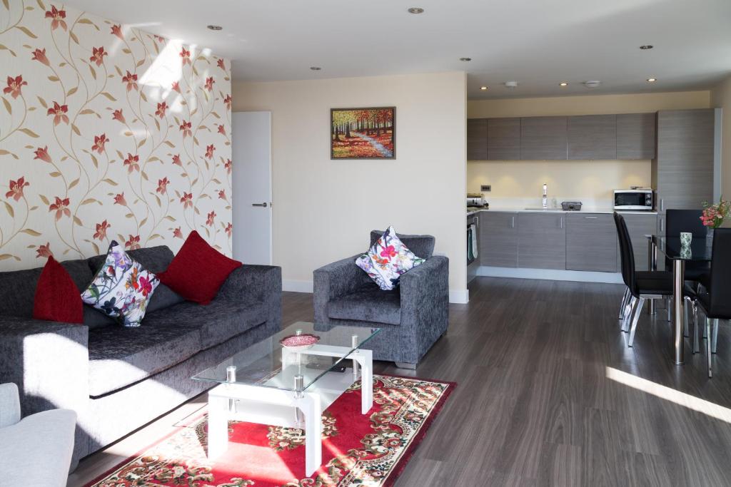 Il comprend un salon avec un canapé et des chaises ainsi qu'une cuisine. dans l'établissement Modern Penthouse, 2 mins walk from Cambridge Station, lift access, secured gated on-site parking, self check-in, SUPER Fast WIFI, Terrace & Sleeps 6, à Cambridge