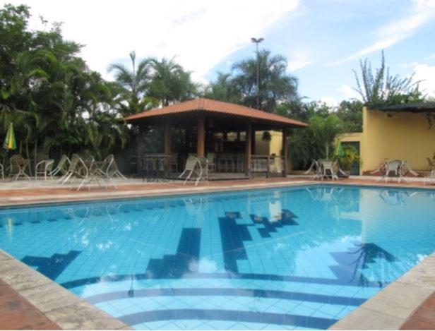 a large blue swimming pool with a gazebo at Mariá Plaza Hotel in Araçatuba