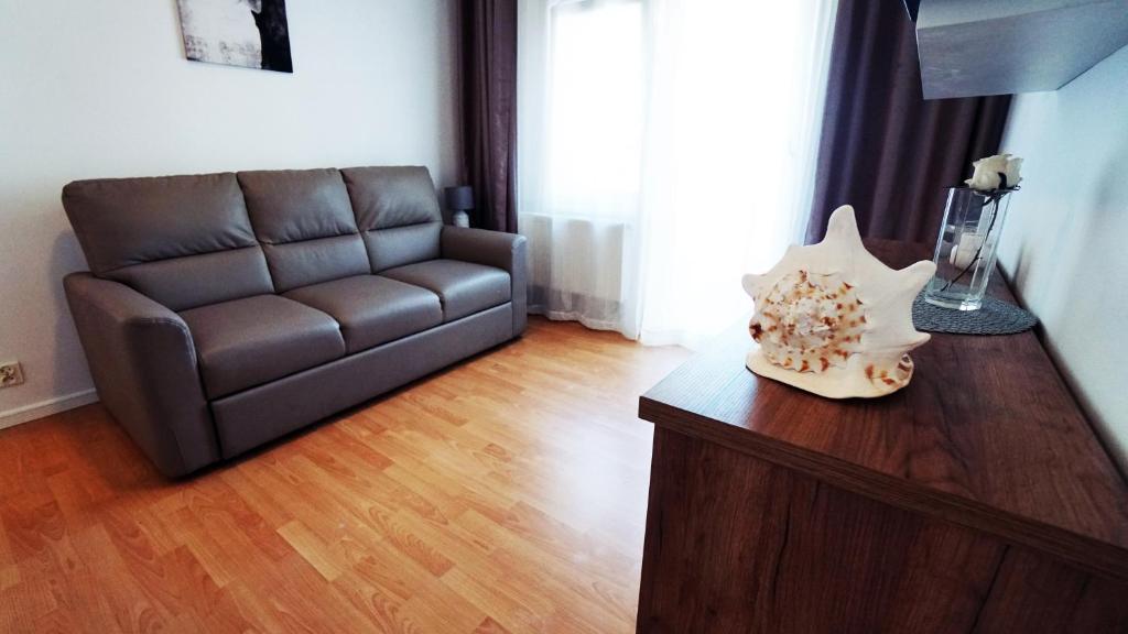 a living room with a leather couch and a table at Apartamenty na pięterku in Mielno