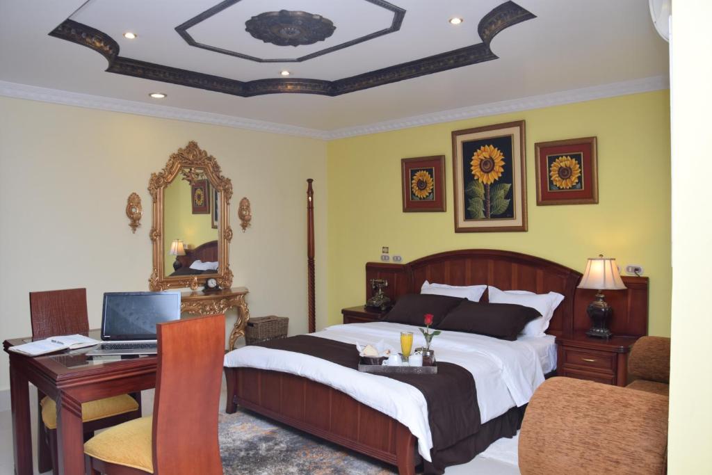 a bedroom with a bed and a desk with a computer at Hotel Perla Verde in Volcán Chimborazo