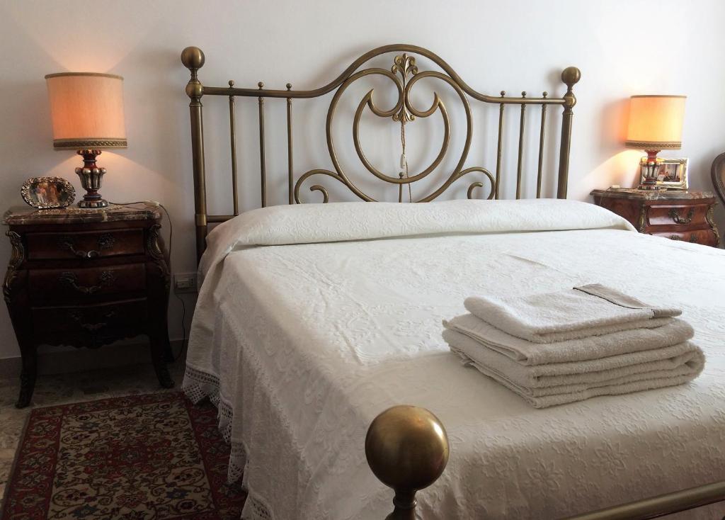 sypialnia z białym łóżkiem z 2 lampami i ręcznikami w obiekcie B&B Pergolesi w Weronie