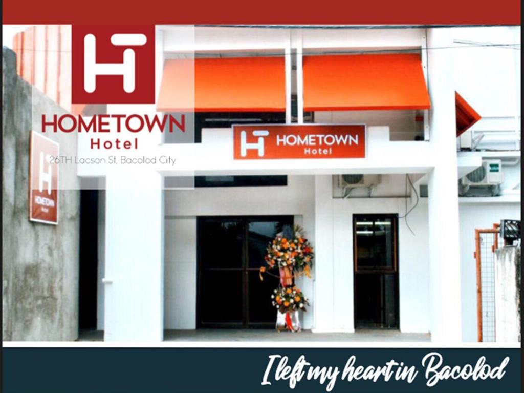 un cartello per un hotel con fiori in una finestra di Hometown Hotel - Lacson Bacolod a Bacolod
