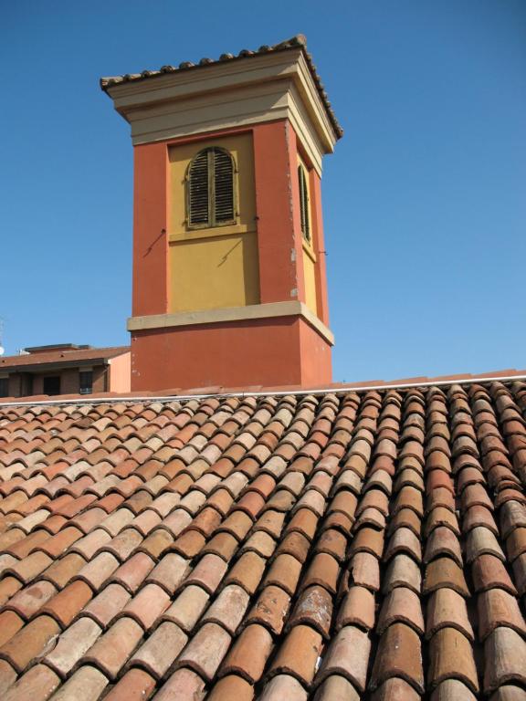 un bâtiment avec une tour d'horloge au-dessus d'un toit dans l'établissement Casa Mozart, à Bologne