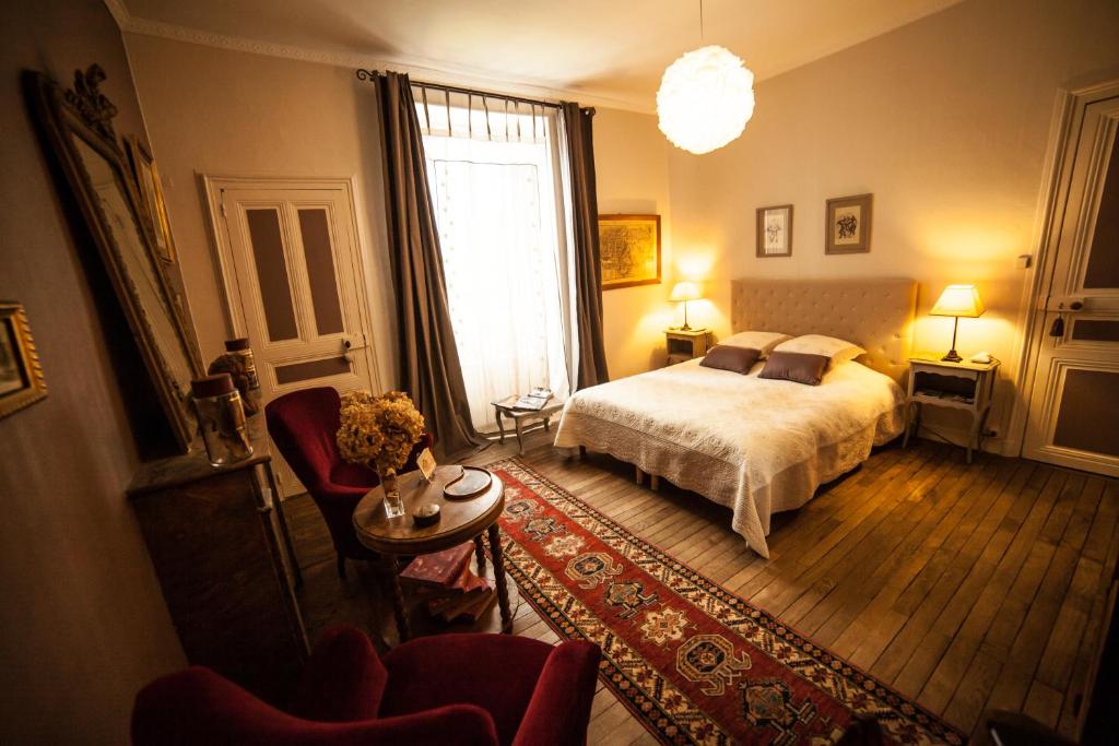 - une chambre avec un lit et un salon dans l'établissement La Pause Angevine, à Angers