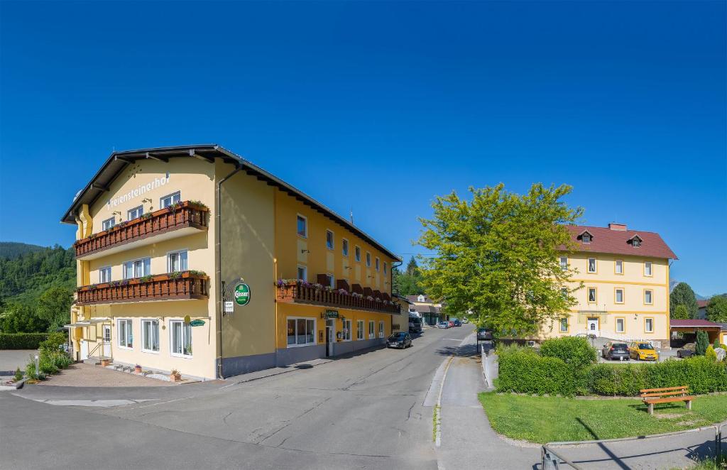 um edifício amarelo no lado de uma rua em Hotel Freiensteinerhof Superior em Sankt Peter-Freienstein