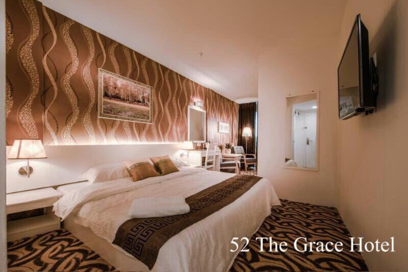 a hotel room with a large bed and a television at 52 The Grace hotel in Muar