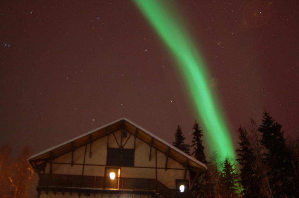 una luce verde nel cielo sopra un edificio di 7 Gables Inn & Suites a Fairbanks