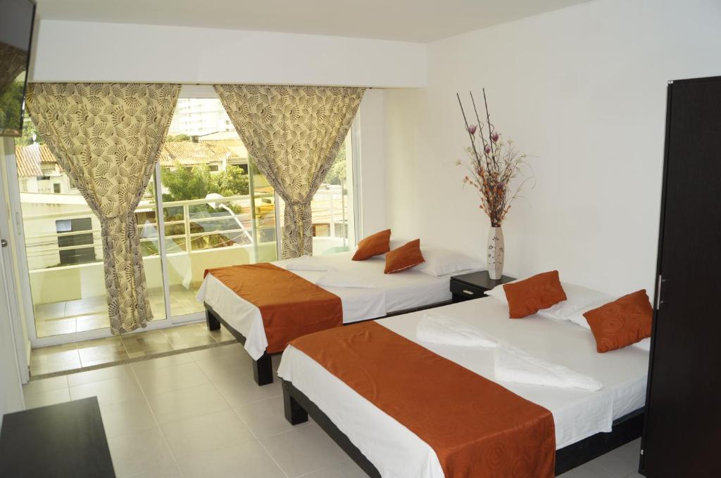 2 camas en una habitación con ventana en Apartahotel Tukasa Rodadero, en Santa Marta