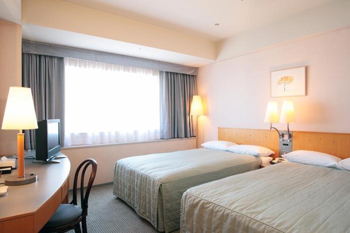 Postel nebo postele na pokoji v ubytování Yokohama Techno Tower Hotel