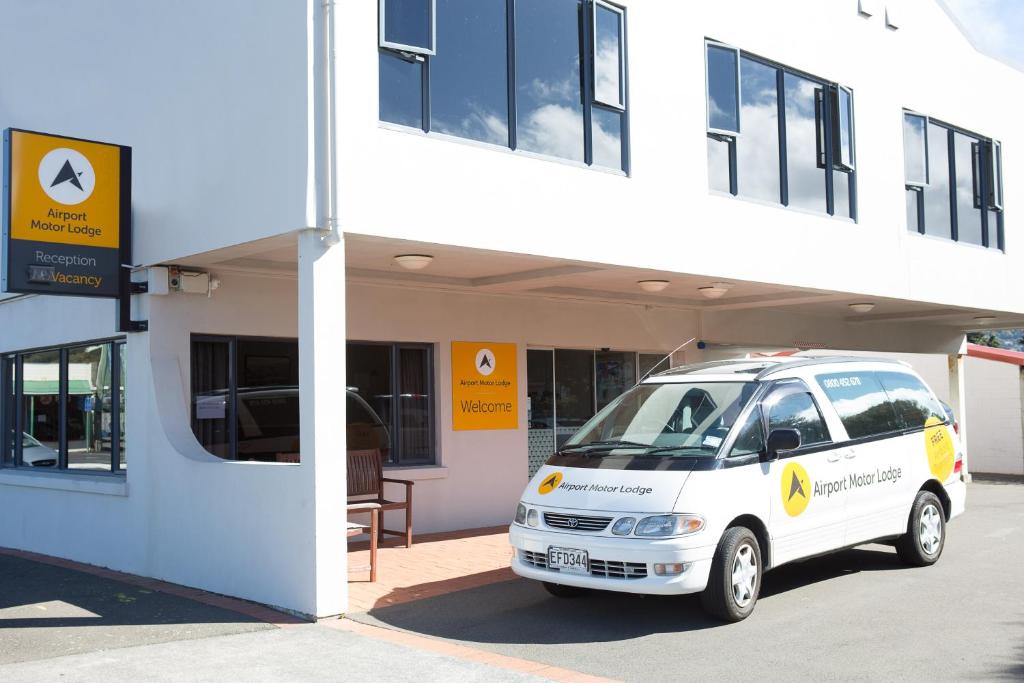 una furgoneta blanca estacionada frente a un edificio en Airport Motor Lodge, en Wellington