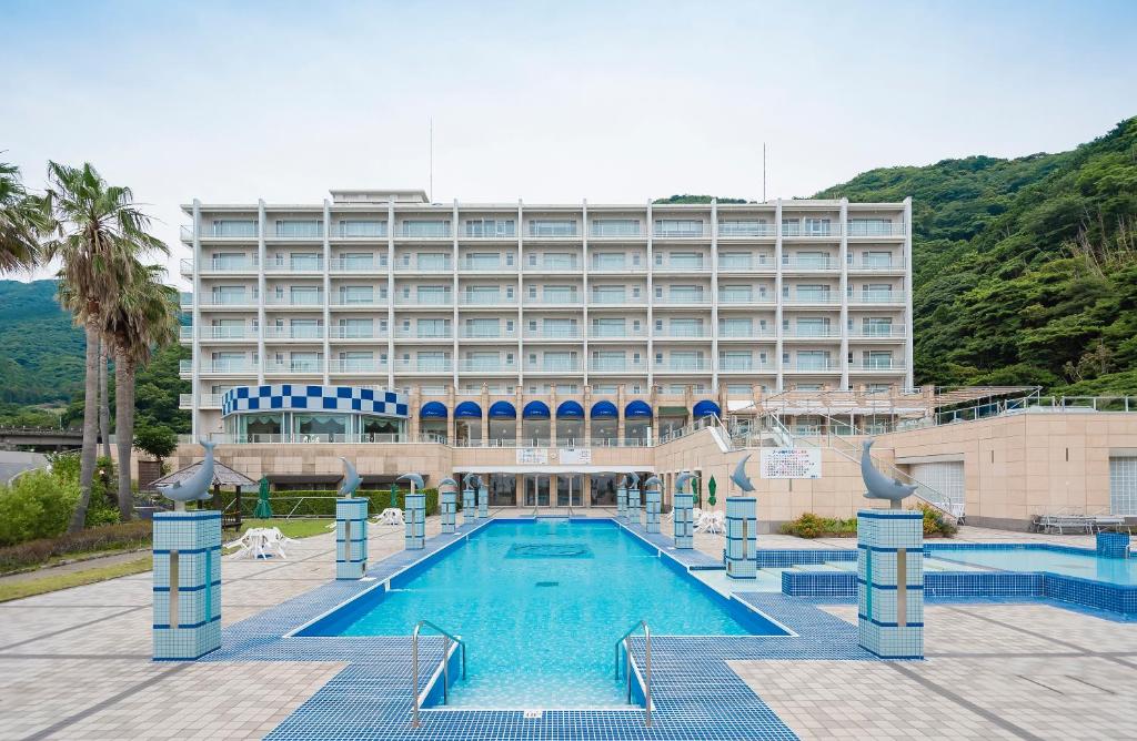 a hotel with a swimming pool in front of a building at Nishiizu Crystal View Hotel in Nishiizu