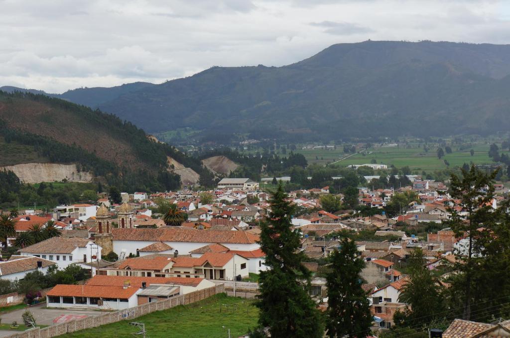 uma pequena cidade com casas e montanhas ao fundo em San Benito Hotel em Tibasosa
