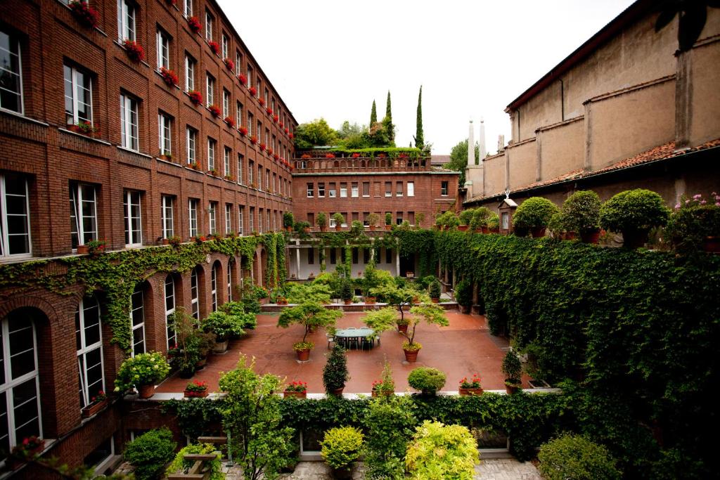 New Generation Hostel Milan Center في ميلانو: ساحة في مبنى به نباتات وأشجار