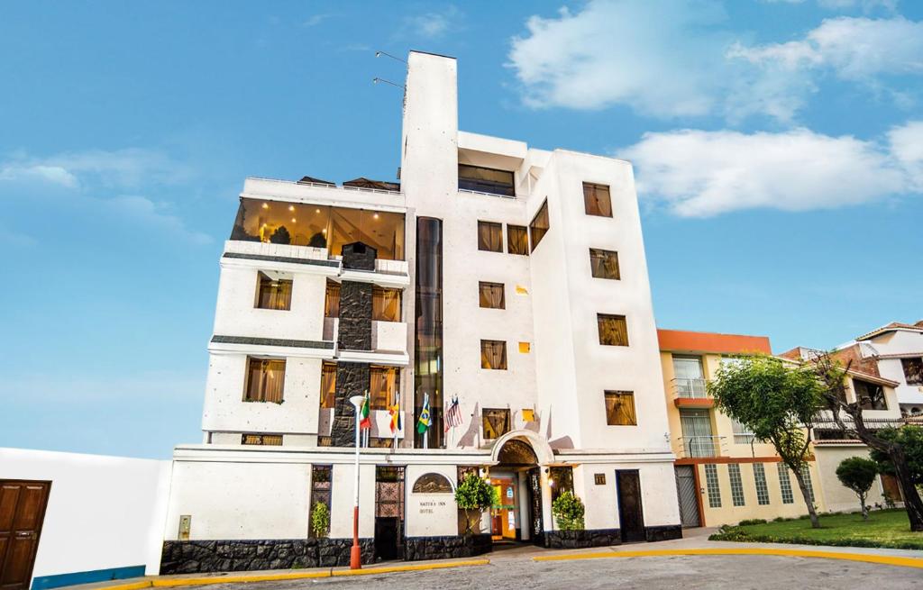 un edificio blanco alto con muchas ventanas en Natura Inn Hotel, en Arequipa