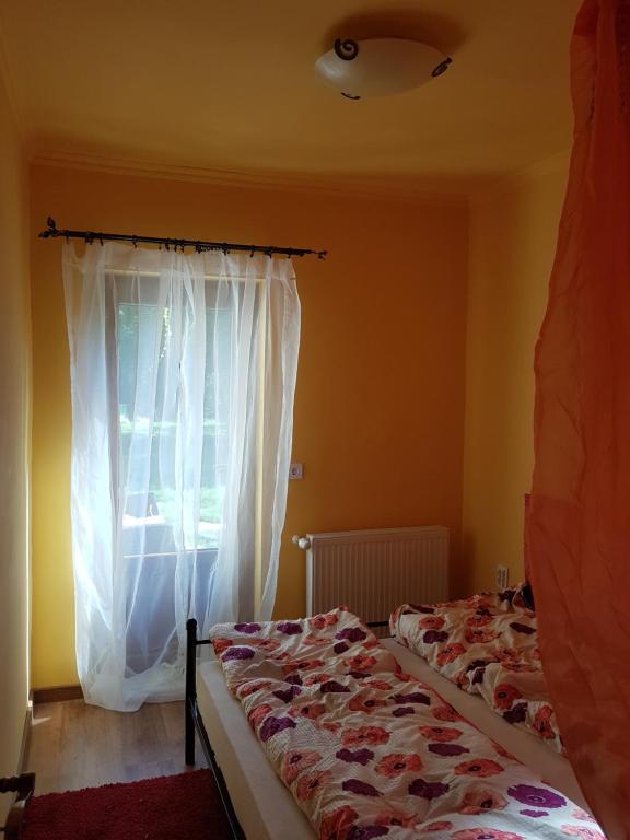 two beds in a room with a window at Etyek Rustic Home in Etyek