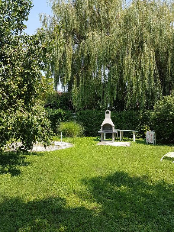 a park with a bench and a weeping tree at Etyek Rustic Home in Etyek