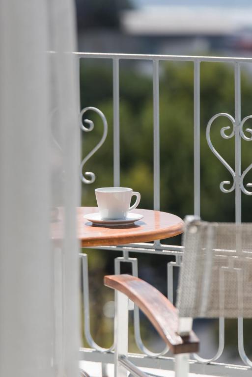 a coffee cup sitting on a table on a balcony at Castello Boutique Rooms in Kavála