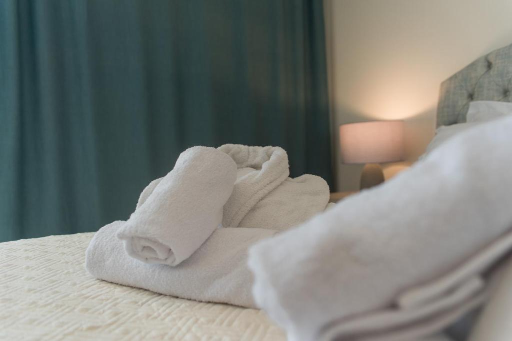 a pile of towels sitting on top of a bed at Castello Boutique Rooms in Kavála