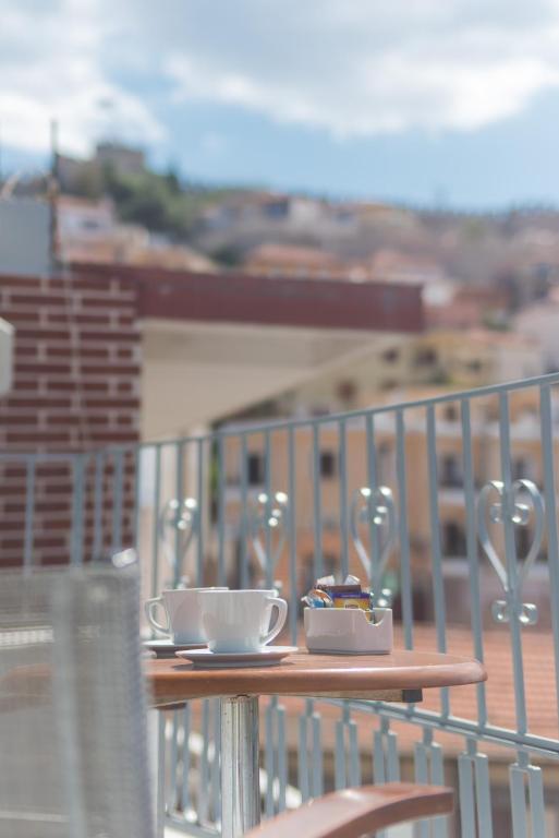 a table with two coffee cups on a balcony at Castello Boutique Rooms in Kavála