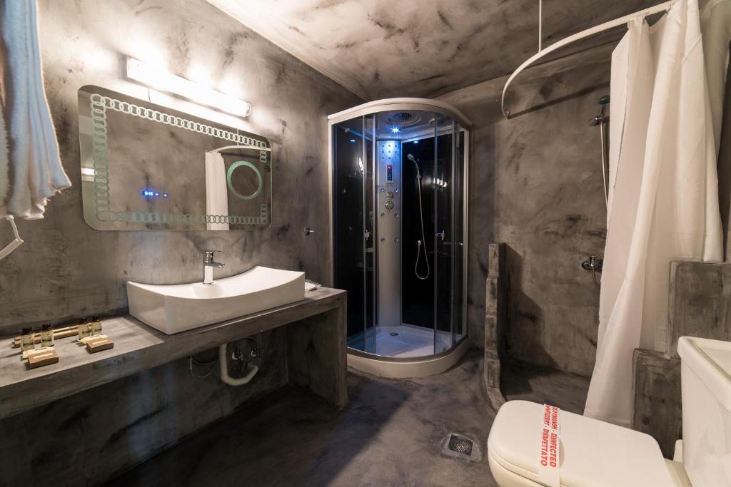 a bathroom with a shower and a sink and a toilet at Castello Boutique Rooms in Kavála