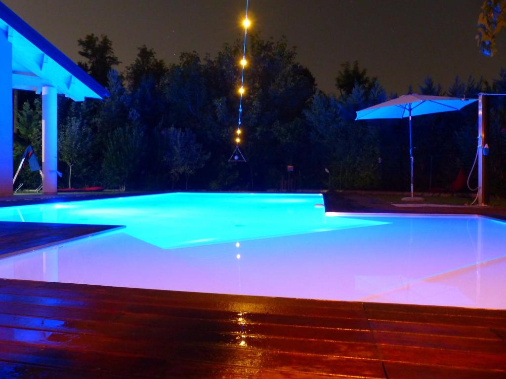 a swimming pool with blue lighting at night at Alla casa del Betto in Porto Mantovano
