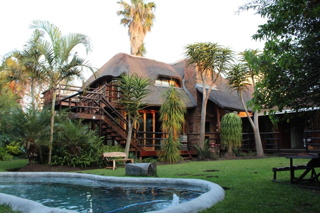 atropical house with a pool in front of it at Tidewaters River Lodge in Gonubie