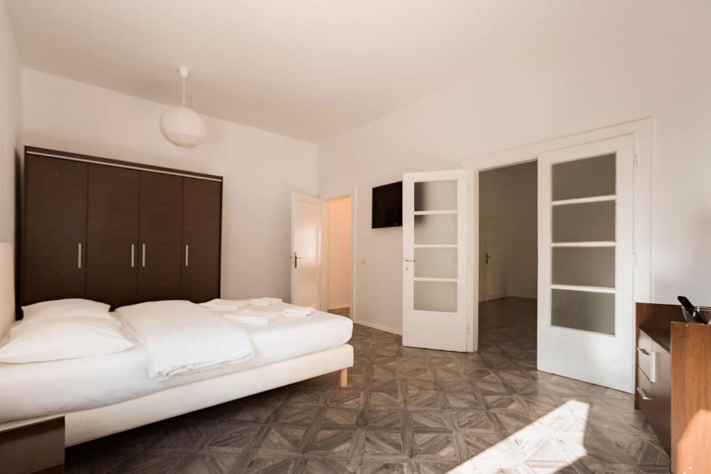 Un dormitorio con una gran cama blanca y un televisor. en M&F Apartment, en Brasov