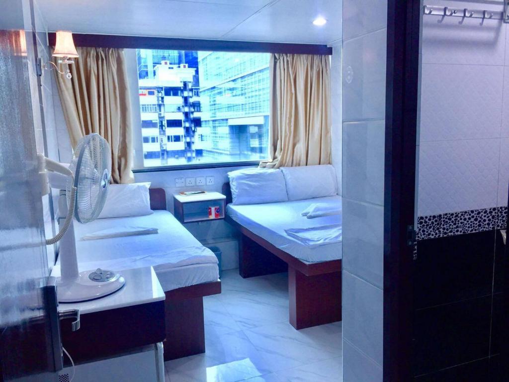 Habitación pequeña con cama y ventana en United Co-Operate Guest House (7/F), en Hong Kong
