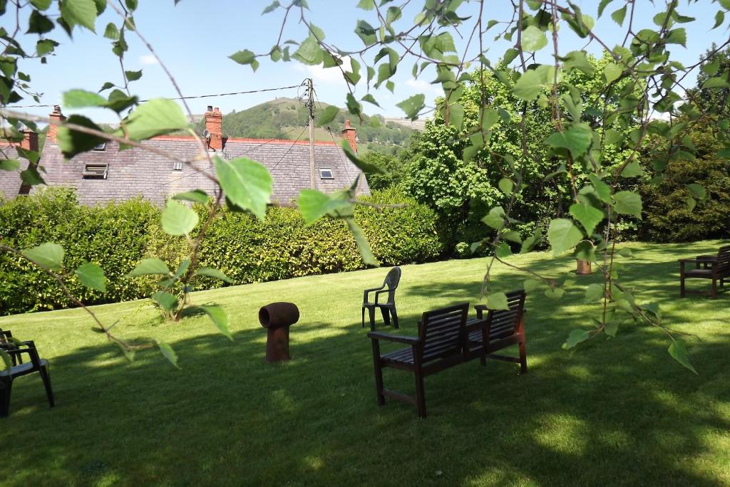 a group of park benches sitting in the grass at Hillcrest Guest House in Llangollen