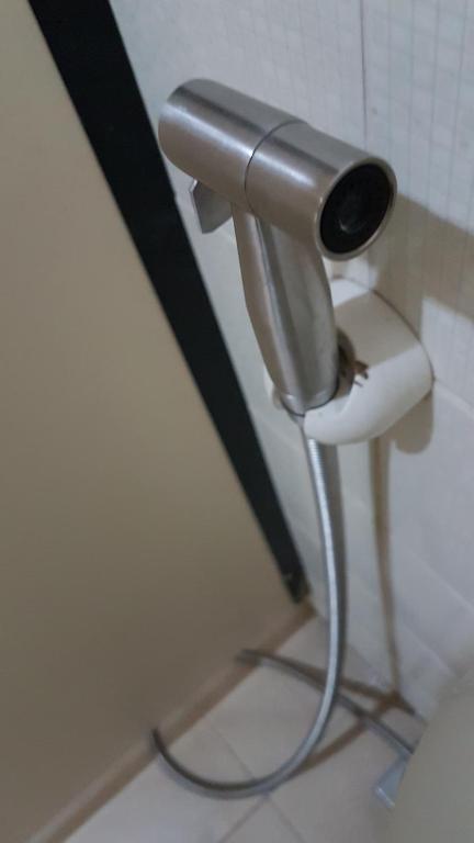 a toilet paper dispenser in a bathroom at Crossroads Hostel Manila in Manila