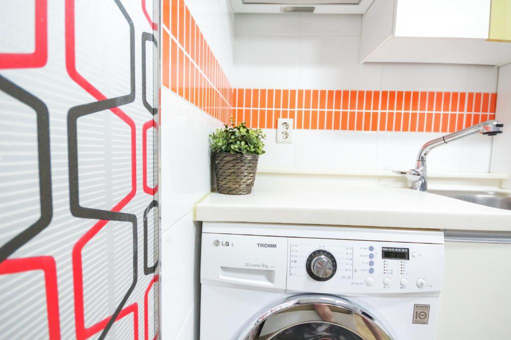 a laundry room with a washing machine and a sink at Zaza Backpackers hostel in Seoul