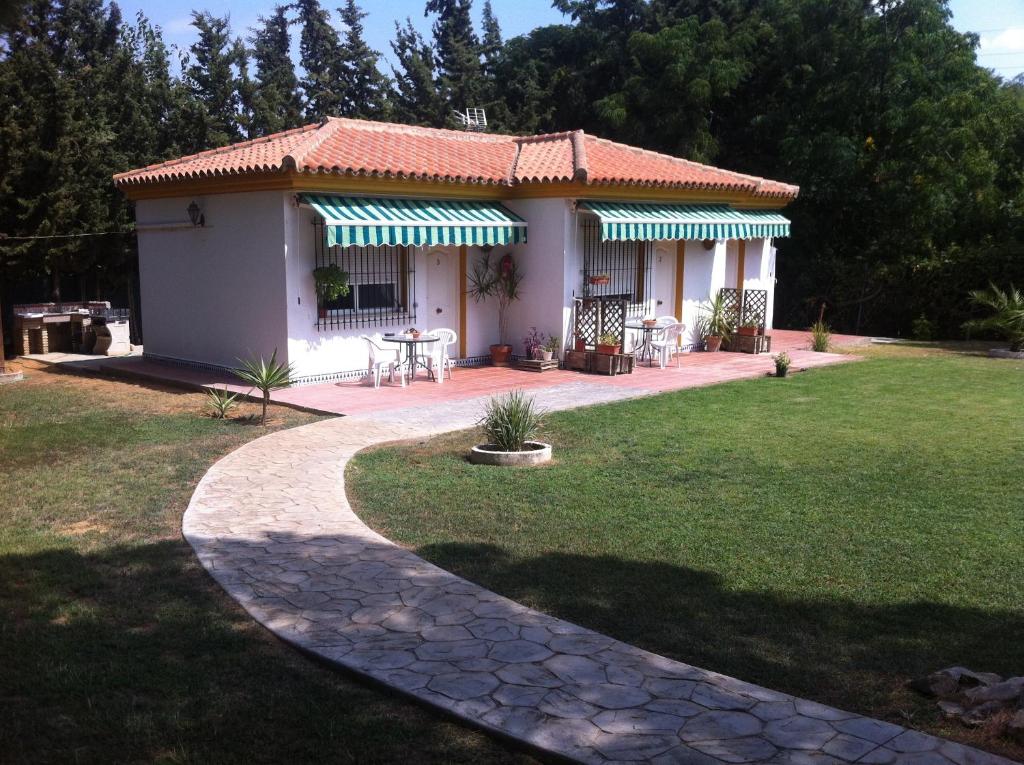 a small house with a patio and a grass yard at Xanadu Rural in Chiclana de la Frontera