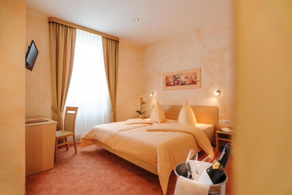 ein Hotelzimmer mit einem Bett und einem Fenster in der Unterkunft Hotel Mediterraneo in Neustadt an der Weinstraße