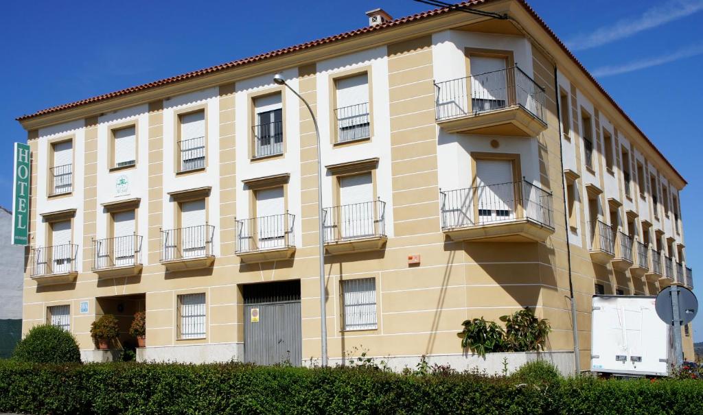 ein gelbes Gebäude mit Balkon an der Seite in der Unterkunft Hotel Apartamentos Kantara Al-Saif in Alcántara