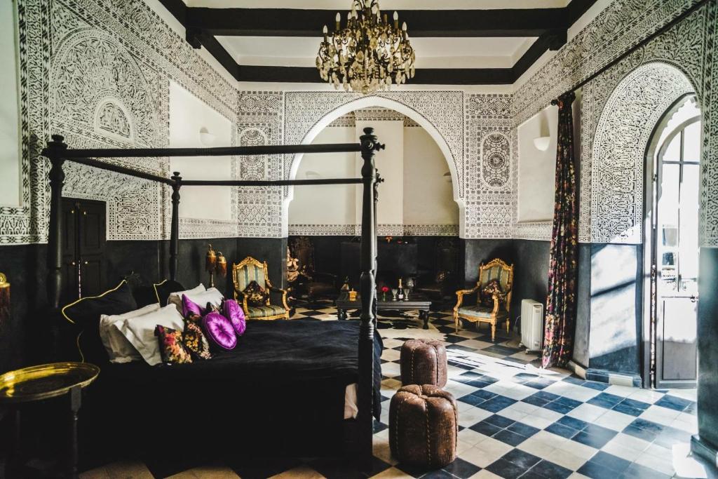 1 dormitorio con cama y lámpara de araña en Riad Dar Jaguar, en Marrakech