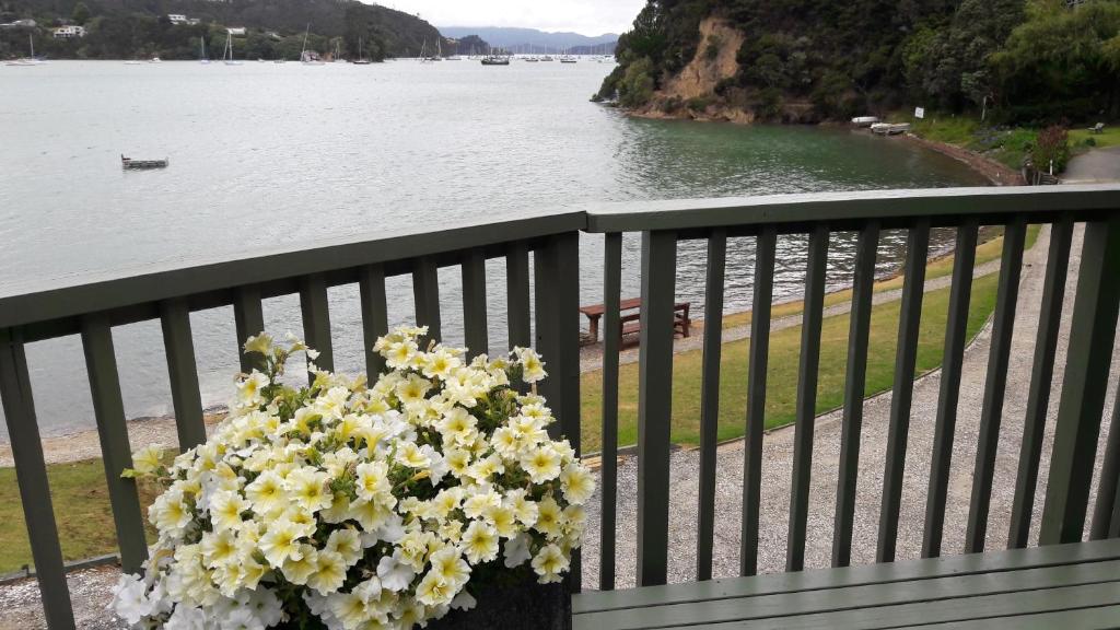 um ramo de flores amarelas e brancas numa varanda em Water's Edge Holiday Home em Opua