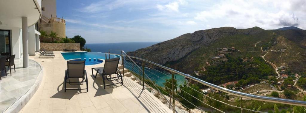 balcón con sillas y vistas a la montaña en Villa Priscilla en Jávea